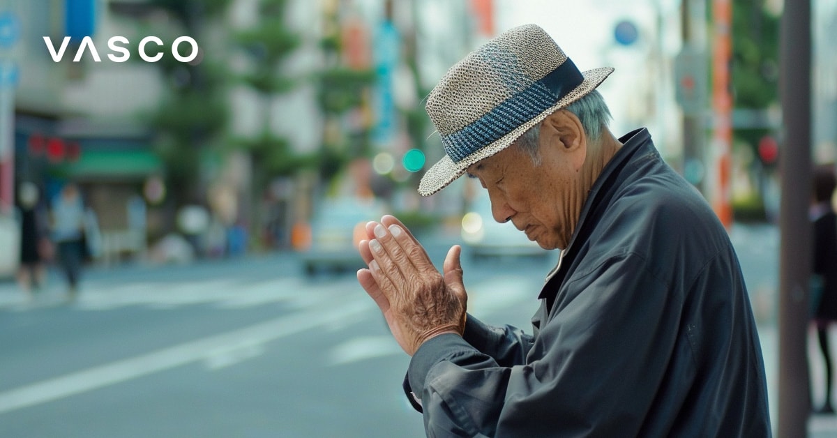 Een oudere man buigt met samengevouwen handen en laat zien hoe je hallo zegt in het Japans.