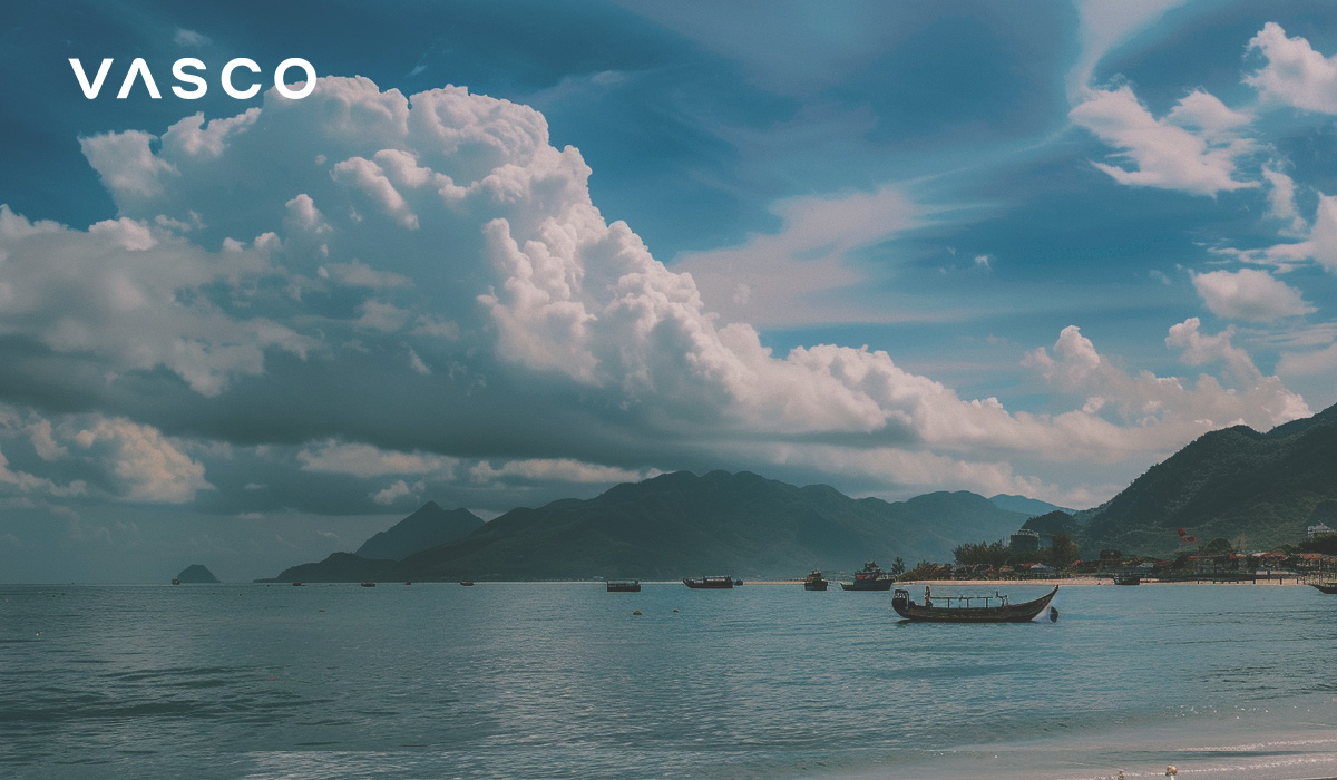 Een strand met boten en bergen op de achtergrond, ter illustratie van de beste periode om naar Vietnam te gaan.