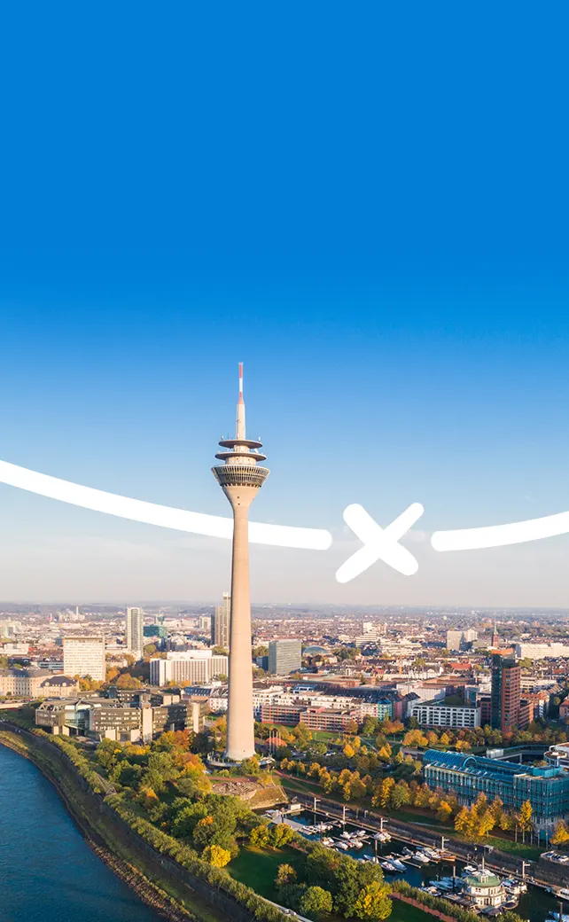 Een weidse luchtfoto van de skyline van Düsseldorf in Duitsland, met de iconische Rheinturm (Rijntoren) als centraal herkenningspunt.