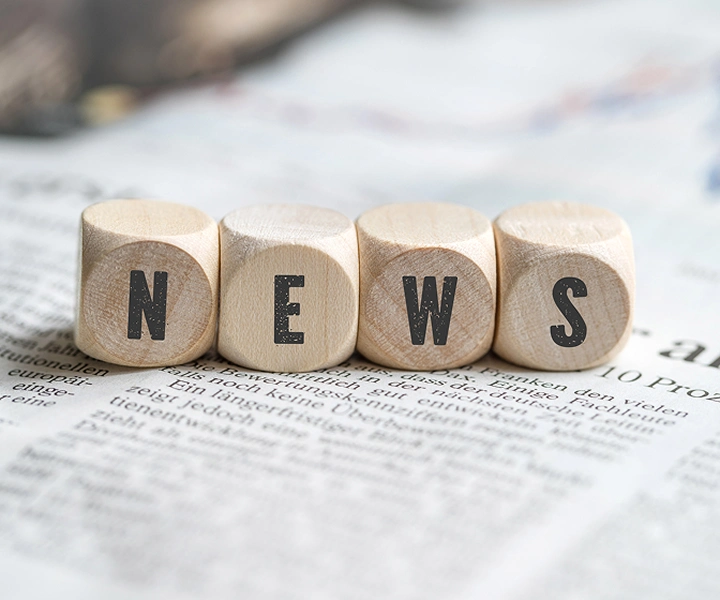 Blokken met het woord ‘NEWS’ die op een krant liggen.