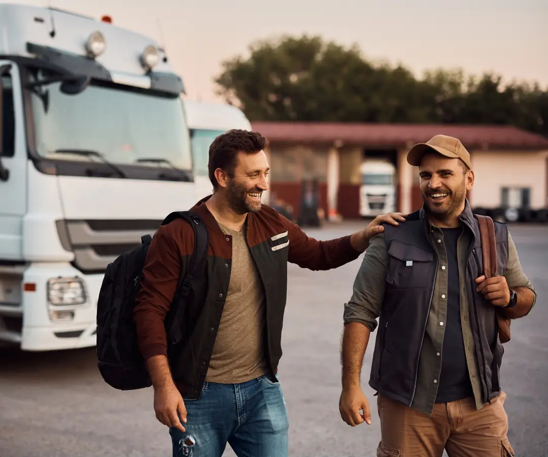twee mannen vol goede moed op een parkeerplaats lopen weg van de vrachtwagens die op de achtergrond geparkeerd staan